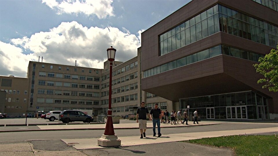 Des étudiants marchent devant un pavillon de l'université.