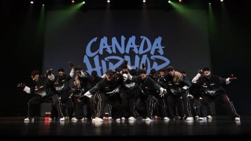 Une dizaine d'adolescents danse sur une scène devant une affiche de Canada Hip Hop.