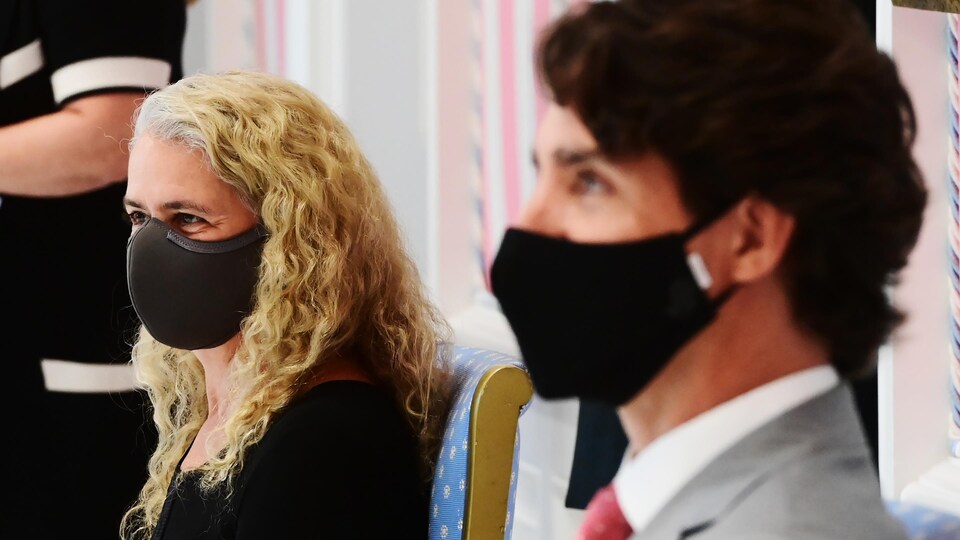 La gouverneure générale Julie Payette et le premier ministre du Canada, Justin Trudeau, sont assis l'un à côté de l'autre et portent chacun un couvre-visage.