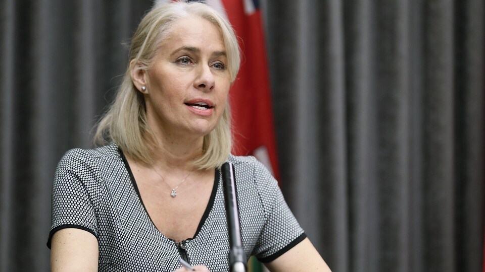 Lanette Siragusa est assise à une table et parle dans un micro devant elle.