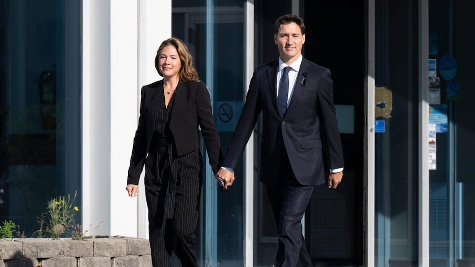 Trudeau and Grégoire Trudeau walking out of a building, hand in hand.