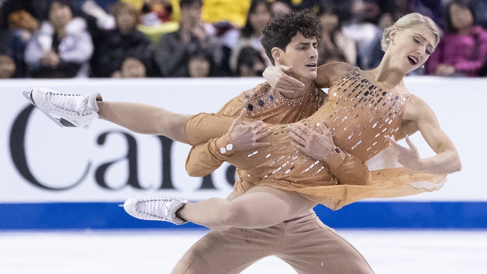 Piper Gilles et Paul Poirier en train de faire une figure sur la glace lors d'une compétition.