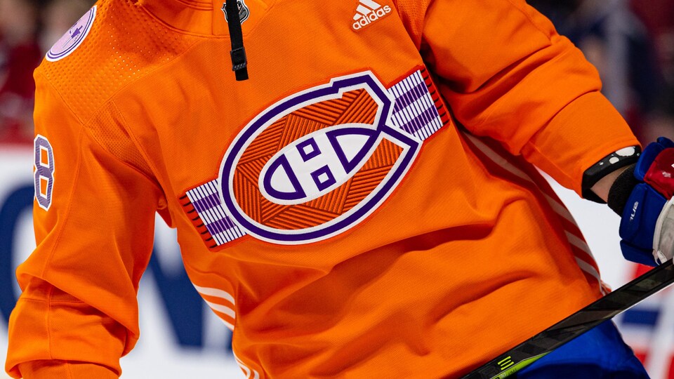 Gros plan sur un chandail orange avec le logo du Canadien de Montréal.