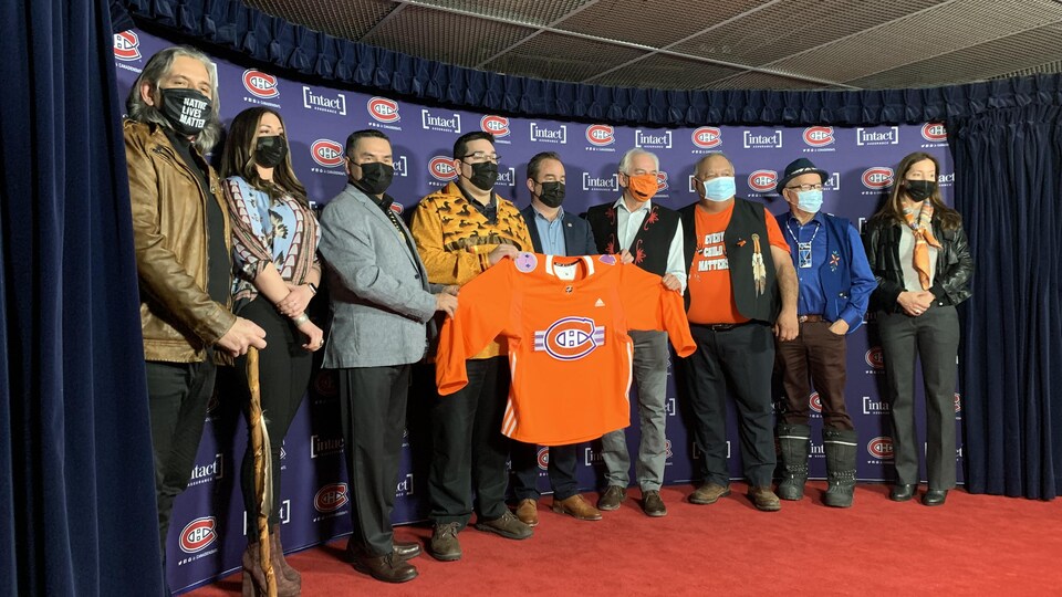 Des chefs autochtones entournent Geoff Molson, qui tient un chandail orange du Canadien de Montréal.