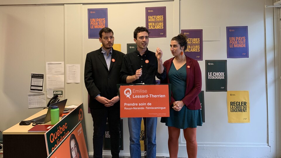 Alexis Lapierre s'adresse aux médias pendant une conférence de presse. Benjamin Gingras et Émilise Lessard-Therrien l'écoute attentivement.