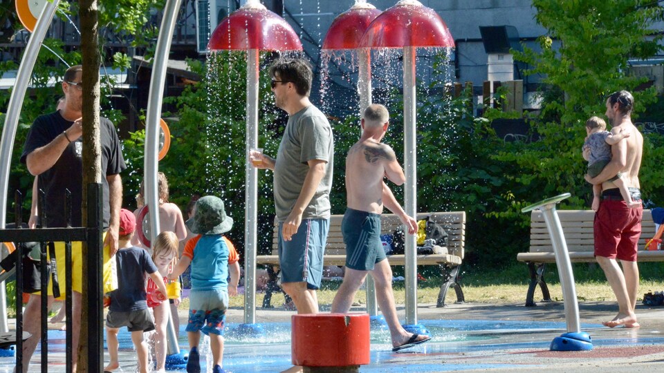 Children and adults in the water games of a park.