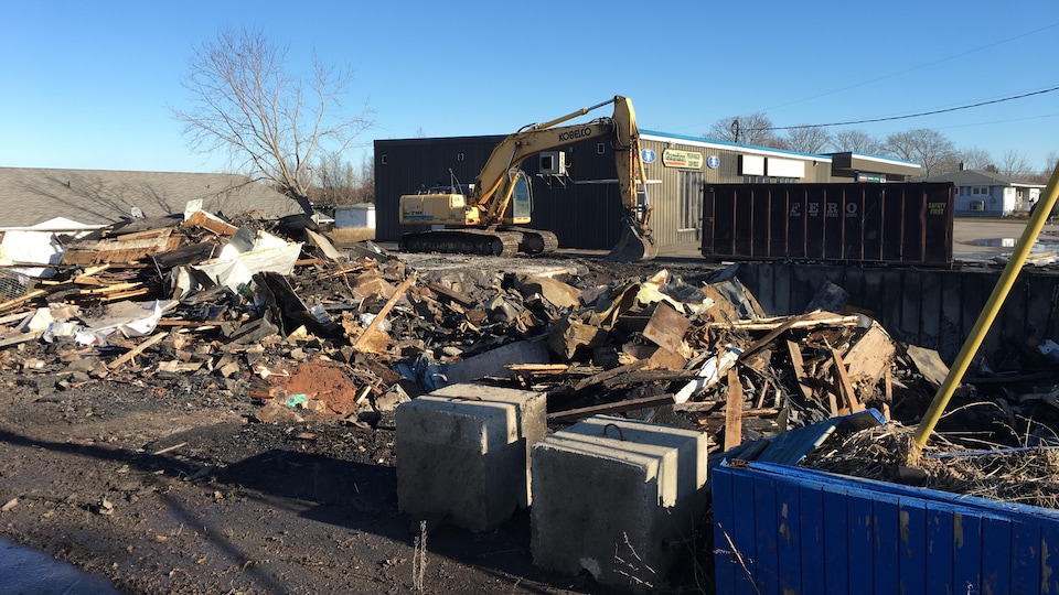 A mechanical shovel cut through the burning rubble.