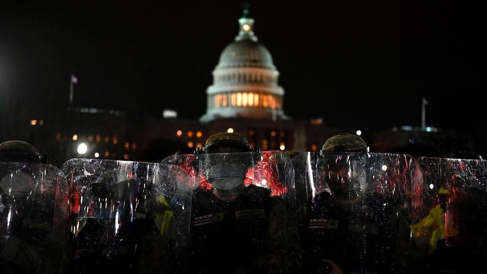 Des policiers et des soldats sont armés de boucliers transparents devant le Capitole.
