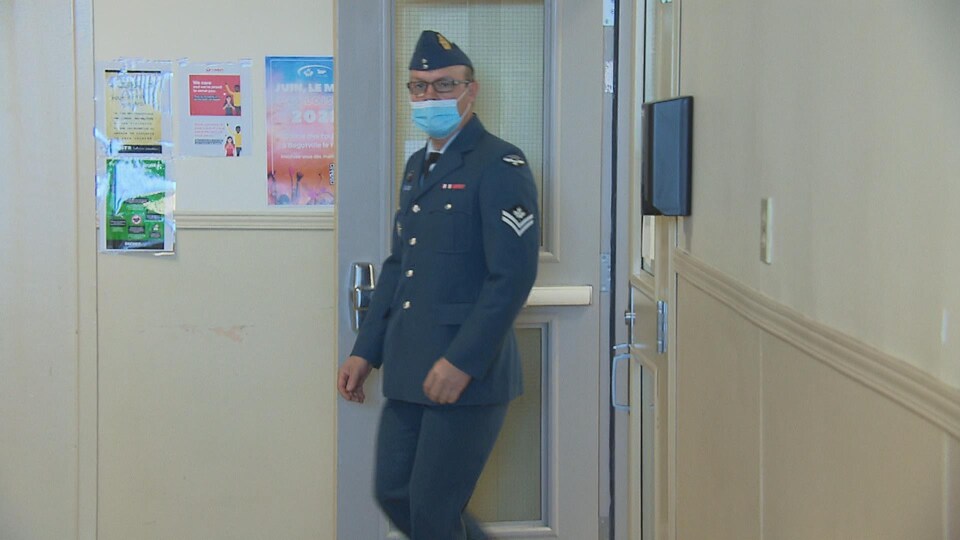 Un militaire entre dans une pièce.