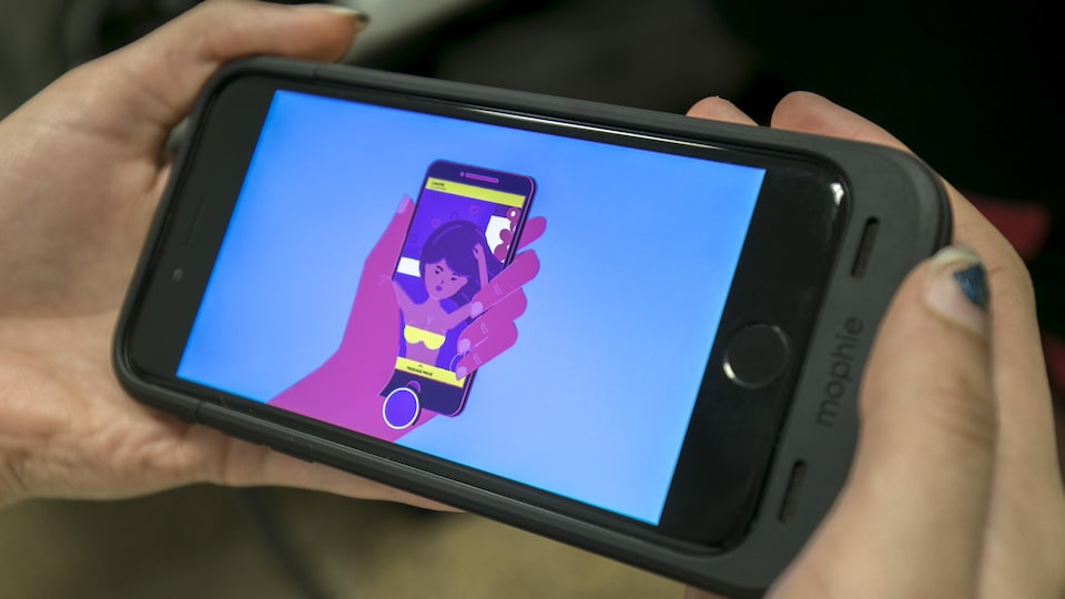 Une adolescente visionne la capsule vidéo sur un téléphone intelligent.