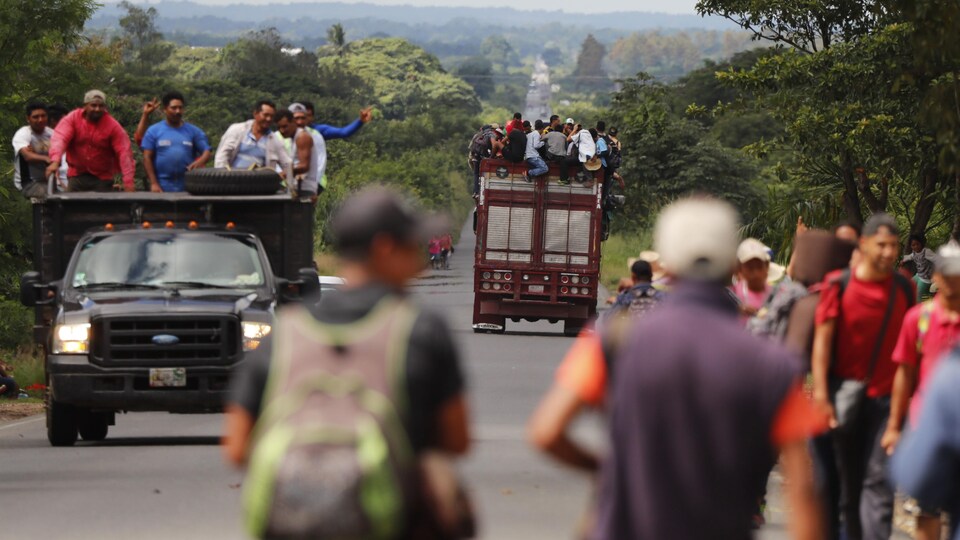 Des migrants latino-américains marchent le long d'une route.
