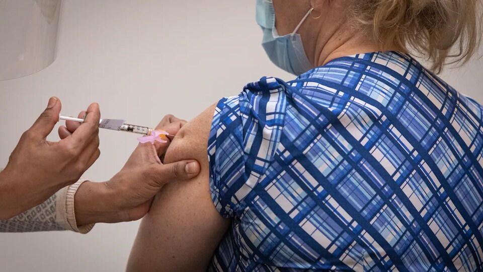 Une personne injecte un vaccin.
