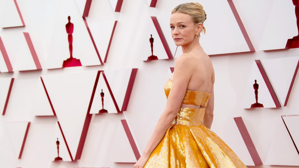 Carey Mulligan, portant une robe dorée, sur le tapis rouge des Oscars.