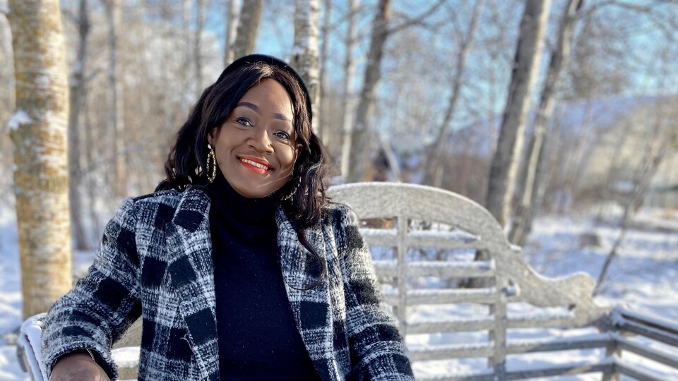 Carine Bado, photographiée dehors en hiver, est souriante.