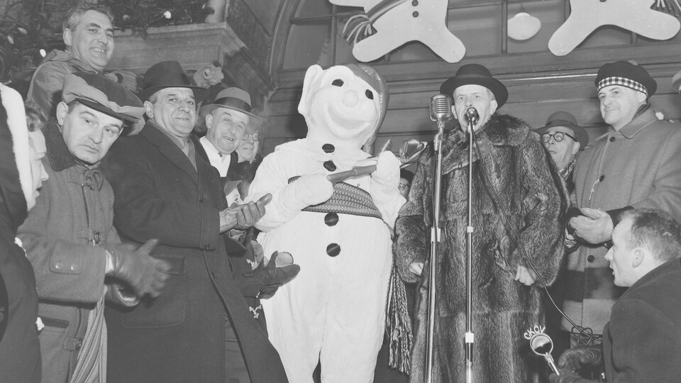 Le maire Hamel avec son nouvel ami Bonhomme Carnaval devant l'hôtel de ville, en 1958, en hiver. Le maire est enveloppé dans un épais manteau de fourrure et bonhomme porte des claques de caoutchouc.