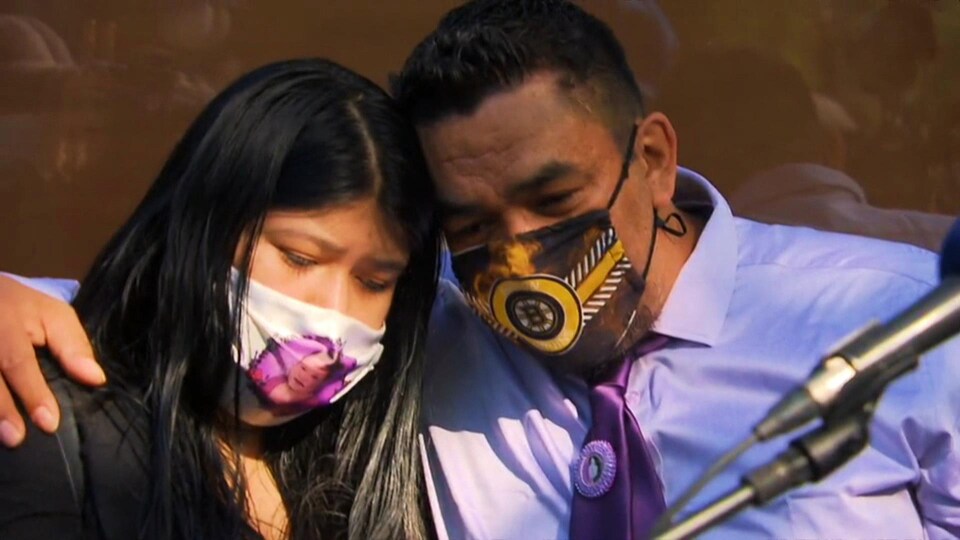 Un homme et sa fille s'enlacent lors d'un moment difficile.