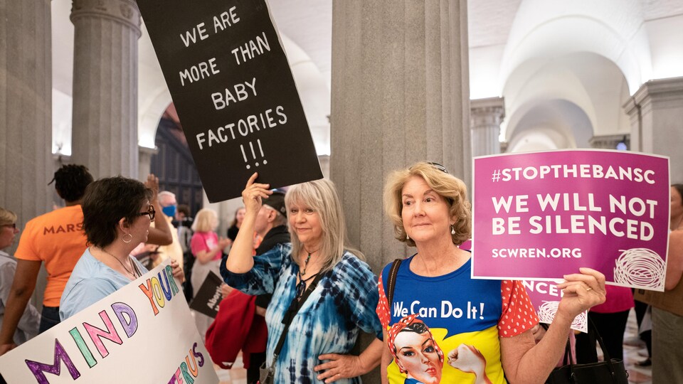 Un groupe de femmes portant des pancartes.
