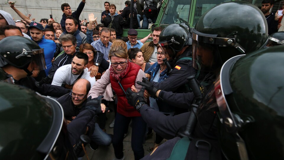 Des agents de la Garde civile espagnole tentent de déloger des Catalans désirant participer au référendum sur l'indépendance.