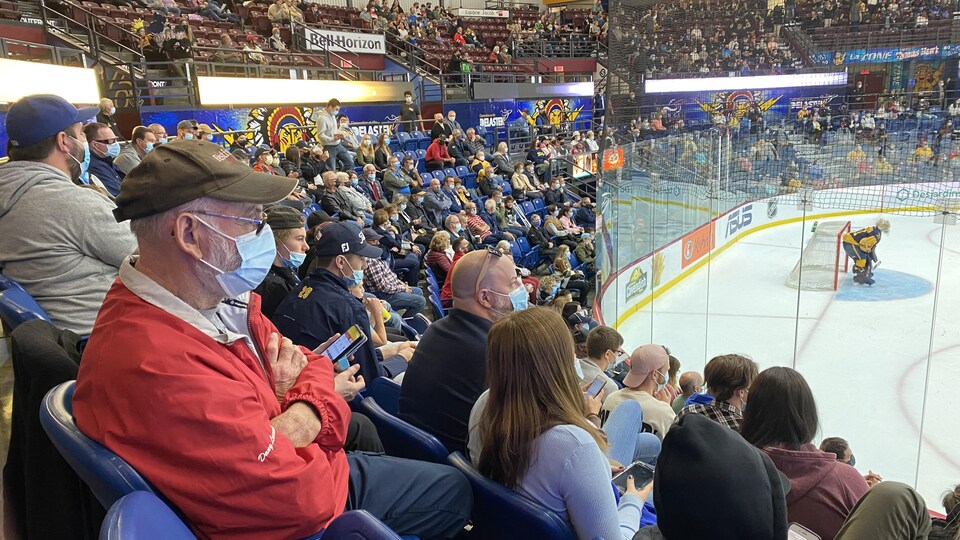 De nombreux spectateurs portant le masque assistent à une partie de hockey des Cataractes de Shawinigan.