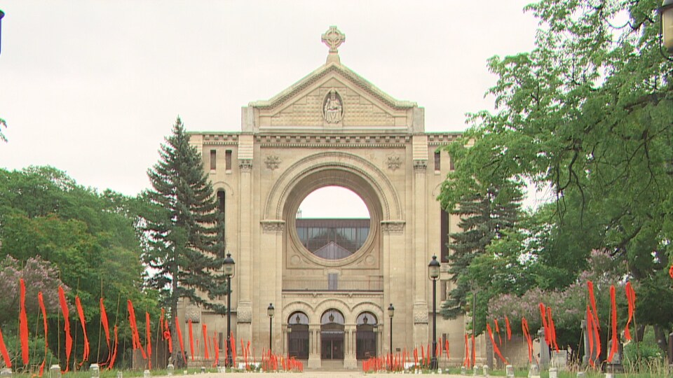 De petits fanions orange sont installés de chaque côté de l'allée menant à la cathédrale de Saint-Boniface.