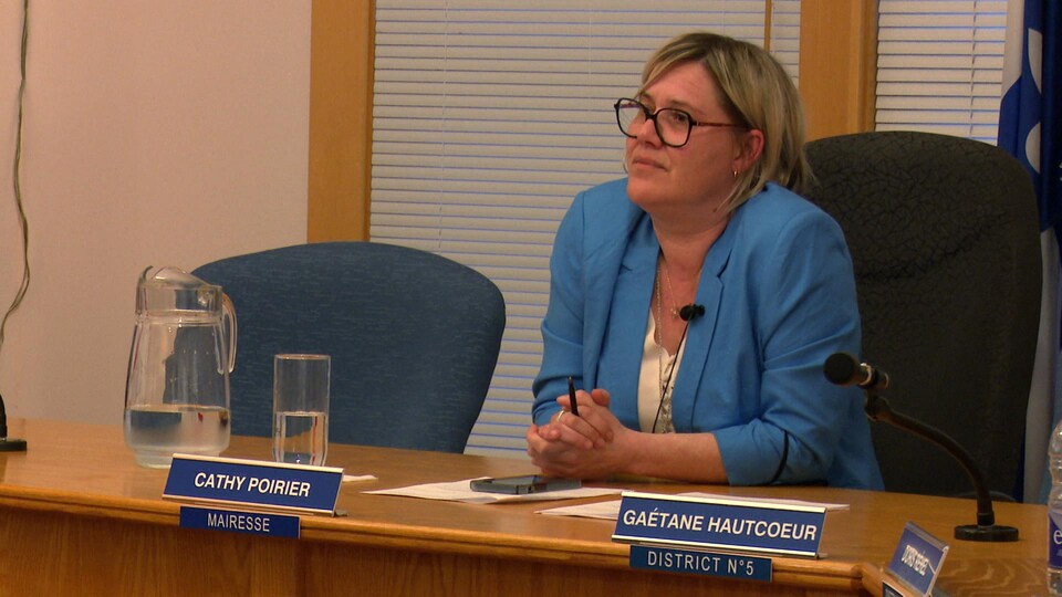 Cathy Poirier est assise à sa place et écoute les citoyens dans la salle du conseil municipal de Percé.
