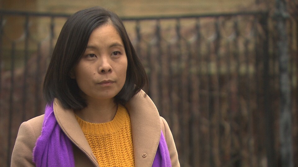 Cathy Wong écoute les questions de notre journaliste, à l'extérieur.