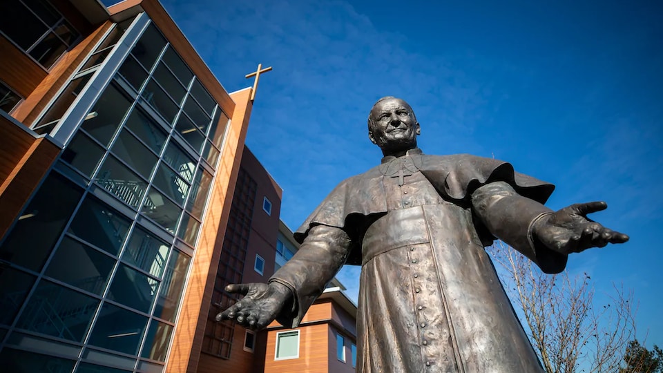 Une statue de bronze représentant le défunt pape Jean-Paul II les bras ouverts est placée devant les bureaux administratifs de l'archidiocèse catholique romain de Vancouver.