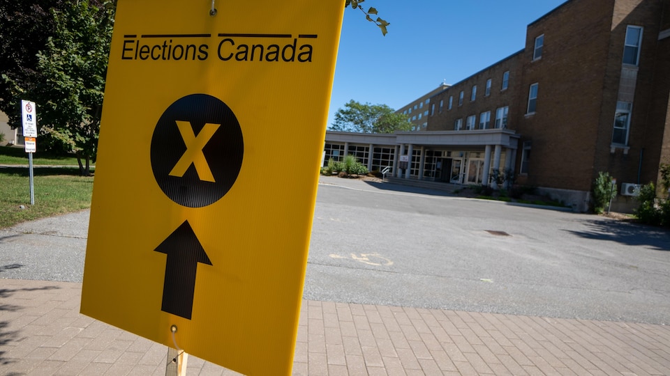 Une affiche d'Élections Canada devant un bureau de scrutin.