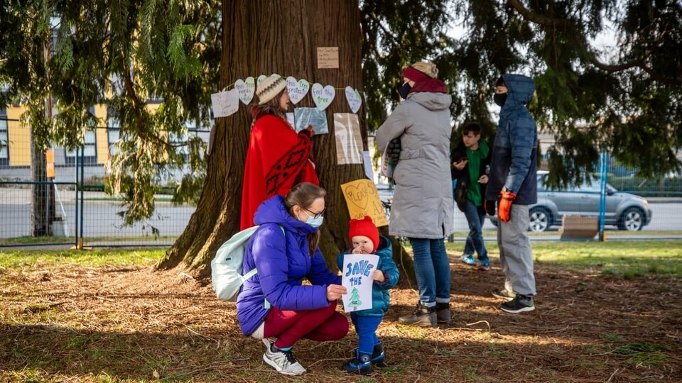 Des gens autour d'un arbre décoré.