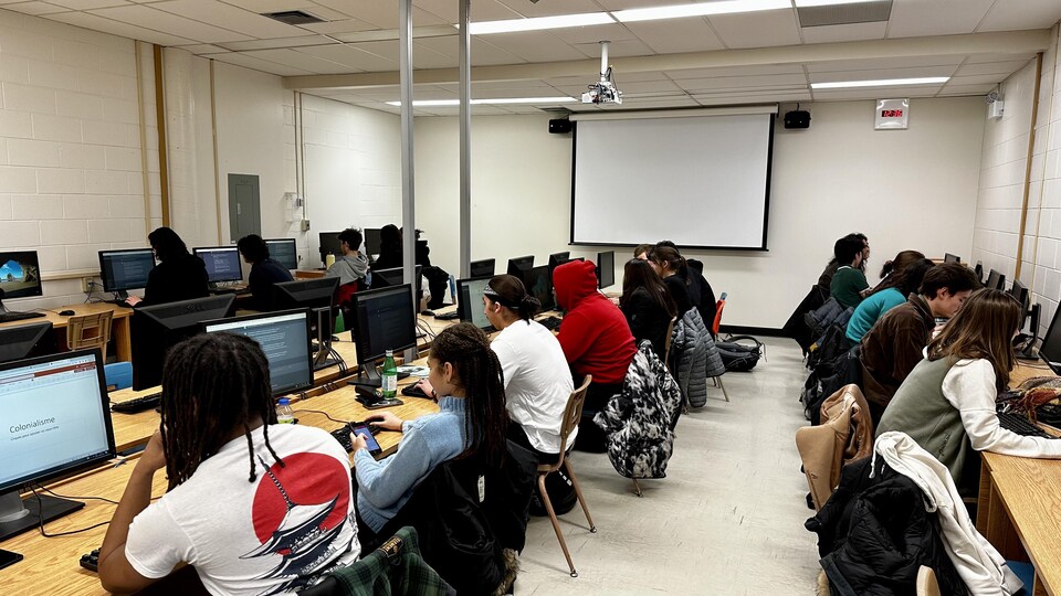 Des étudiants du Cégep de l'Outaouais assis devant des ordinateurs. 