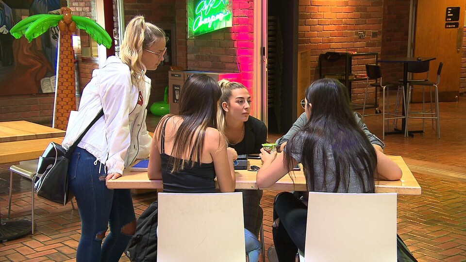 Cinq filles discutent autour d'une table