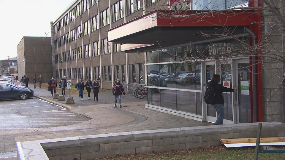 Des élèves avec des masques entrent à l'école.