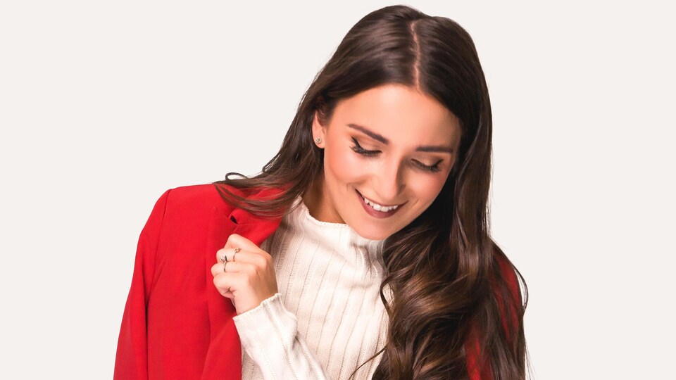 Une femme pose dans un manteau rouge.