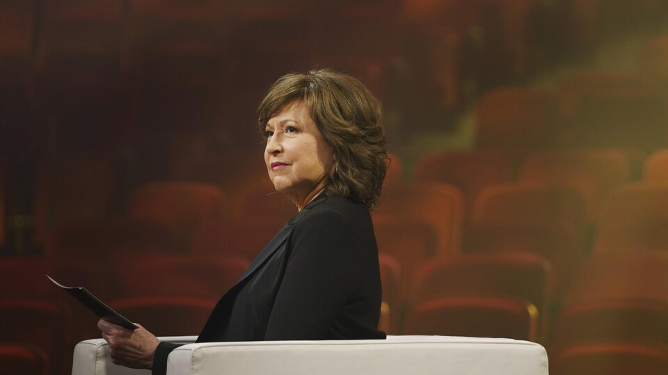Céline Galipeau assise dans un théâtre.