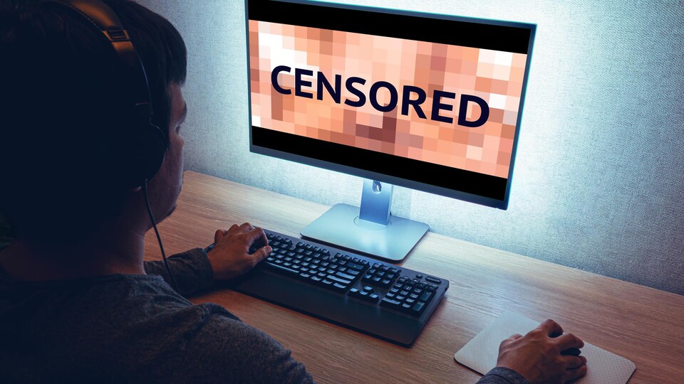 Un homme assis à un ordinateur, le contenu de l'écran est censuré.