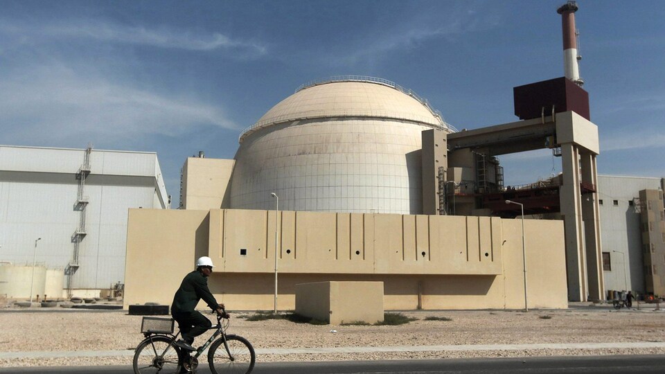 Un cycliste passe devant les installations d'une centrale nucléaire.