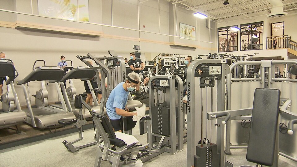 De gens masqués sur les appareils d'entraînements au Centre athlétique Trois-Rivières.