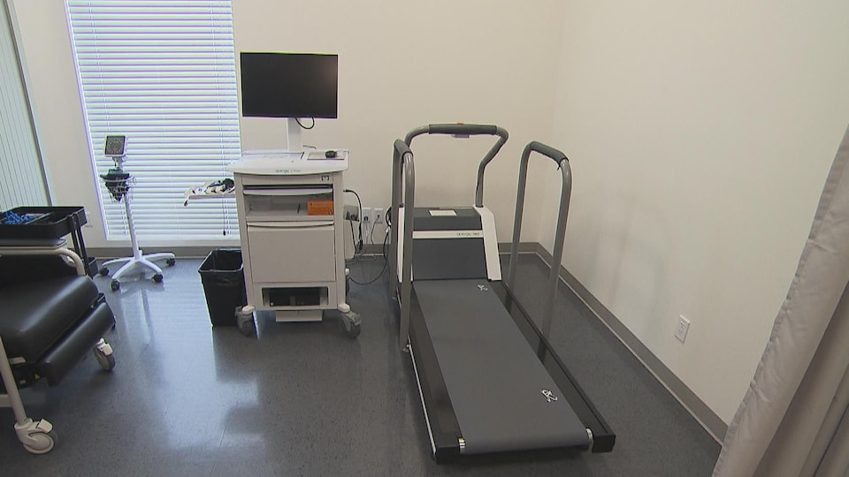 Un tapis de marche et un écran d'ordinateur dans une salle de consultation.
