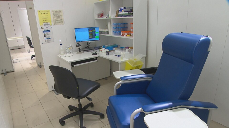 Une chaise bleue dans un petit laboratoire blanc.
