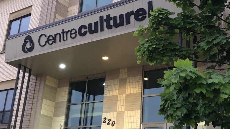 Une photo de l'entrée du Centre culturel, en contre-plongée, avec un arbre non loin.