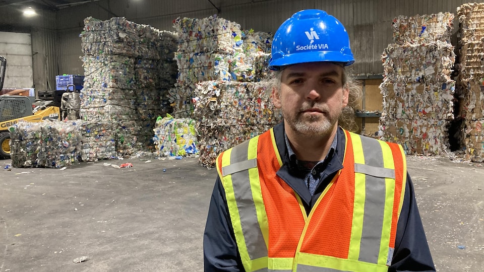 Jimmy Bouchard pose devant des ballots de recyclage.