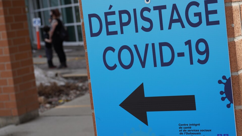 Une affiche indiquant l'entrée d'un centre de dépistage.