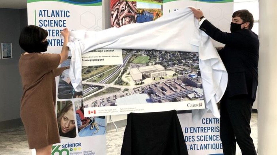 Ginette Petitpas-Taylor et Dominic LeBlanc retirent un toile blanche cachant une pancarte du concept.