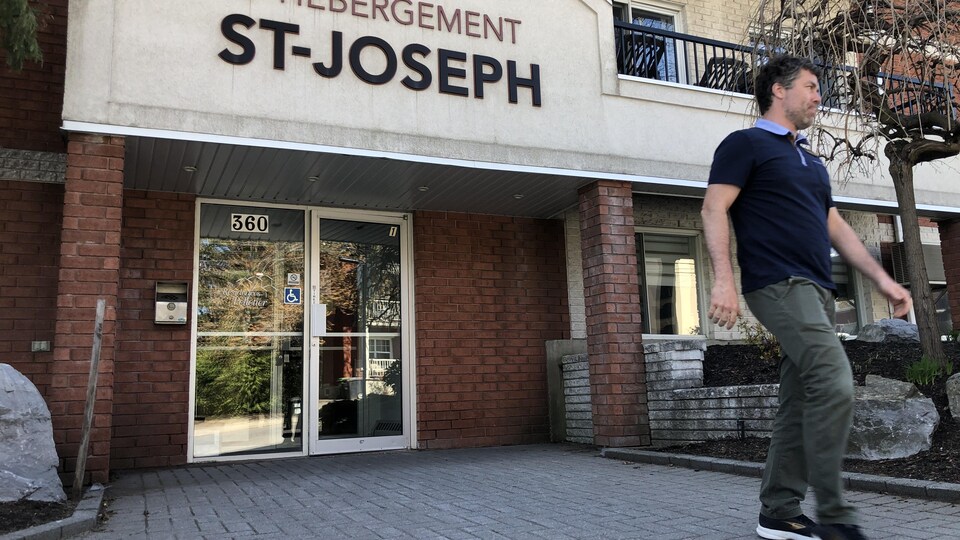 Un homme qui sort d'un centre d'hébergement pour aînés.