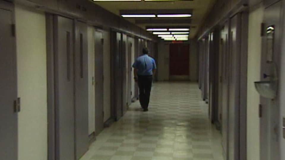 Un agent correctionnel marche dans un corridor de la prison.