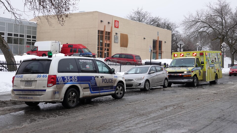 Une voiture de police et une ambulance stationnée devant le centre Père-Marquette.