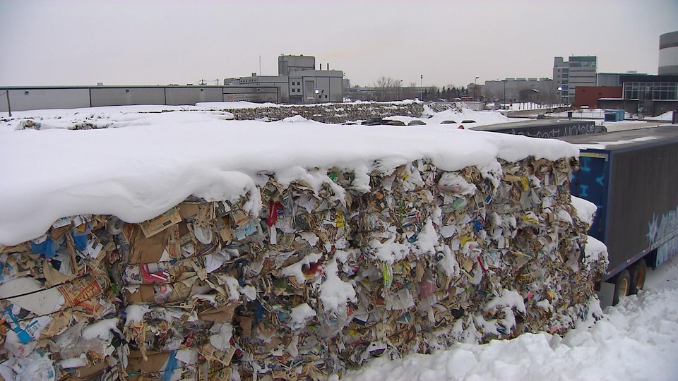 Des ballots de matières recyclables dans la neige, près du même centre, à Montréal, en janvier 2018 derrière des camions
