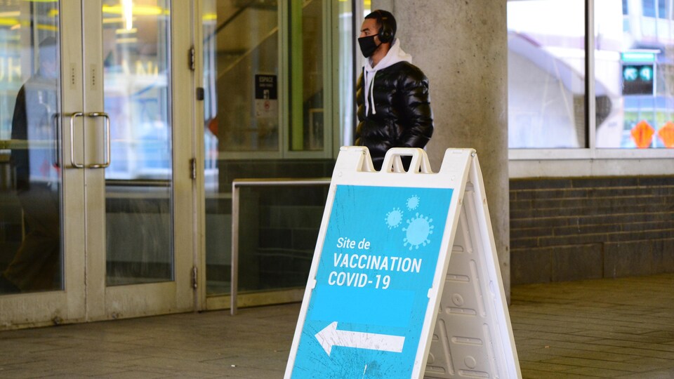 Un homme portant un masque est sur le point d'entrer dans un centre de vaccination contre la COVID-19.