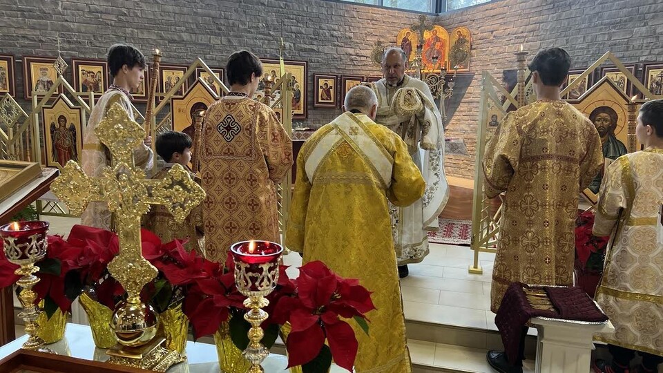 Des prêtres orthodoxes habillés de vêtements dorés célèbrent une messe.