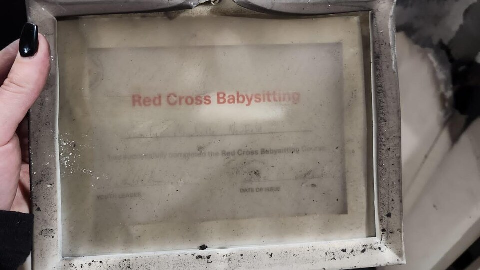 Le certificat de gardiennage d’enfants donné par la Croix-Rouge. Le feu a laissé ses traces sur le cadre.